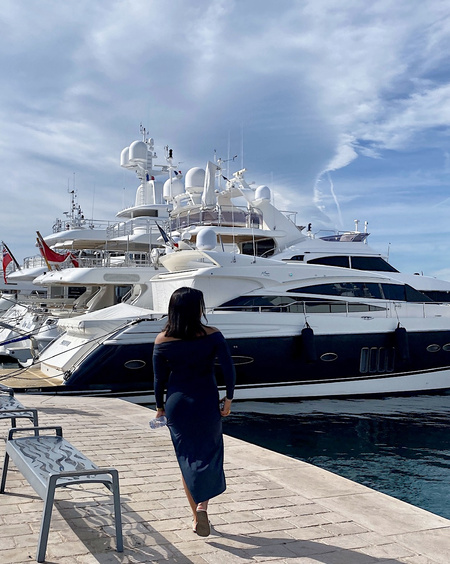 travel ugc creator posing on holiday front of a yacht 